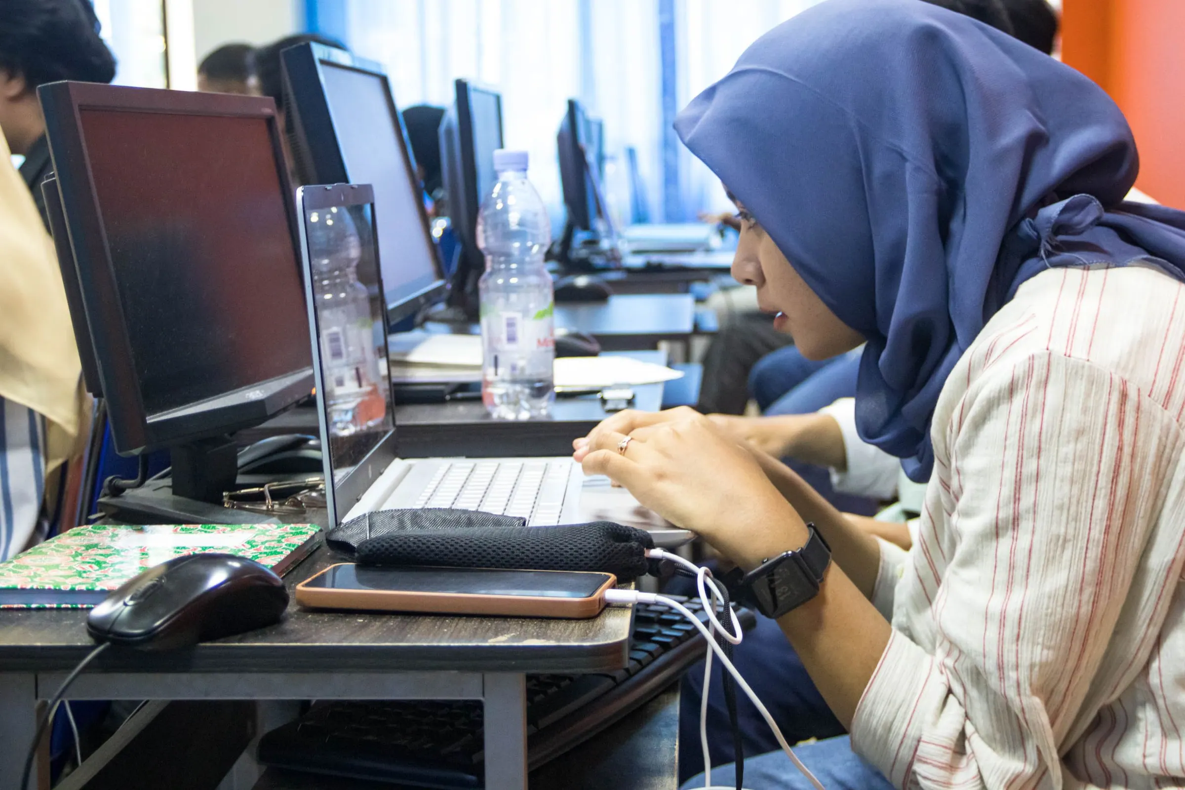A young woman using a computer in a training class