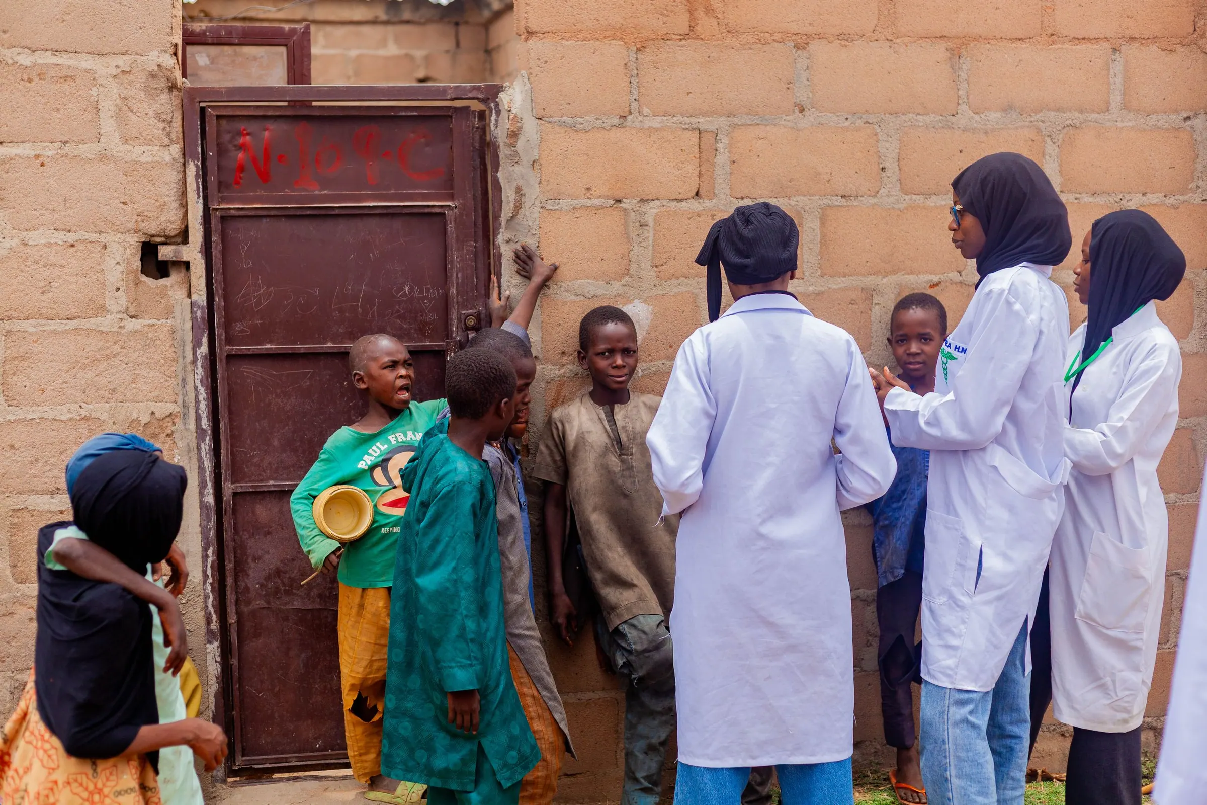 Health workers talking with children in a community