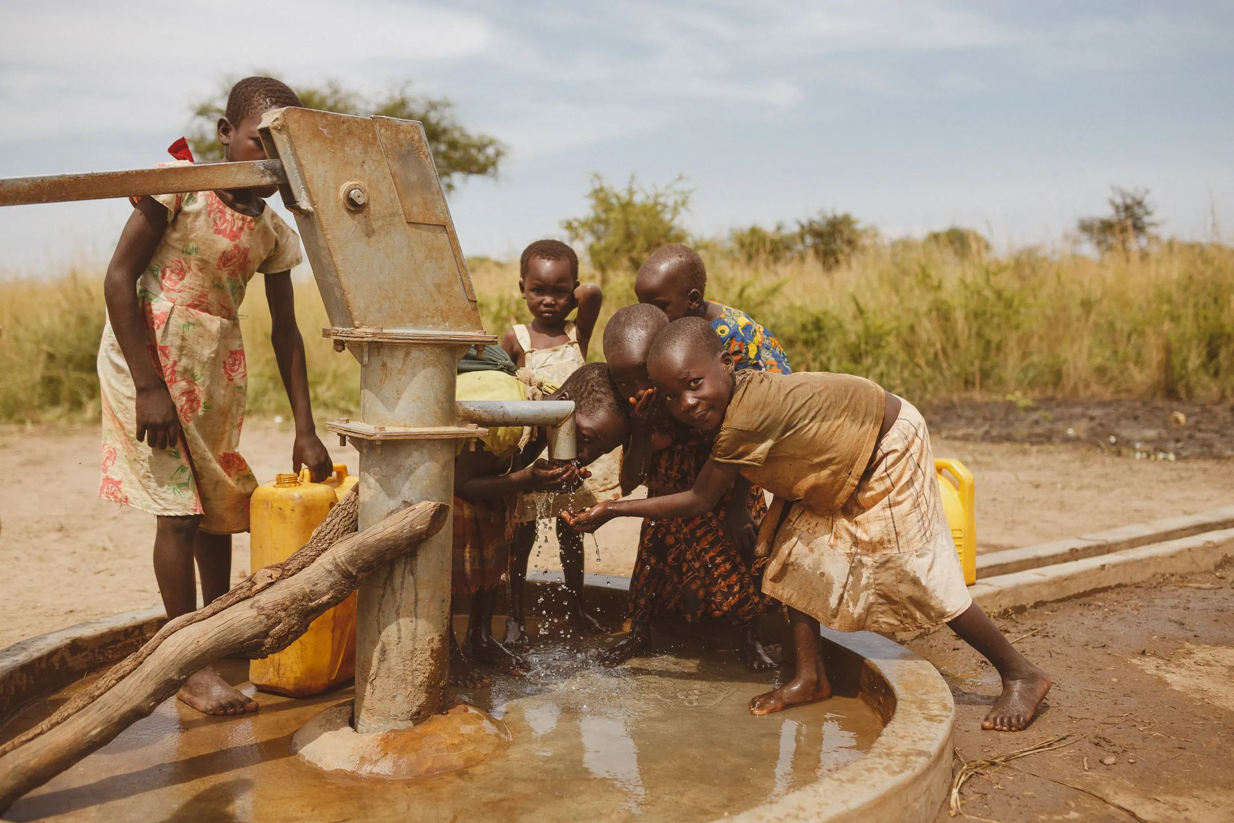 Children drawing water from a hand pump