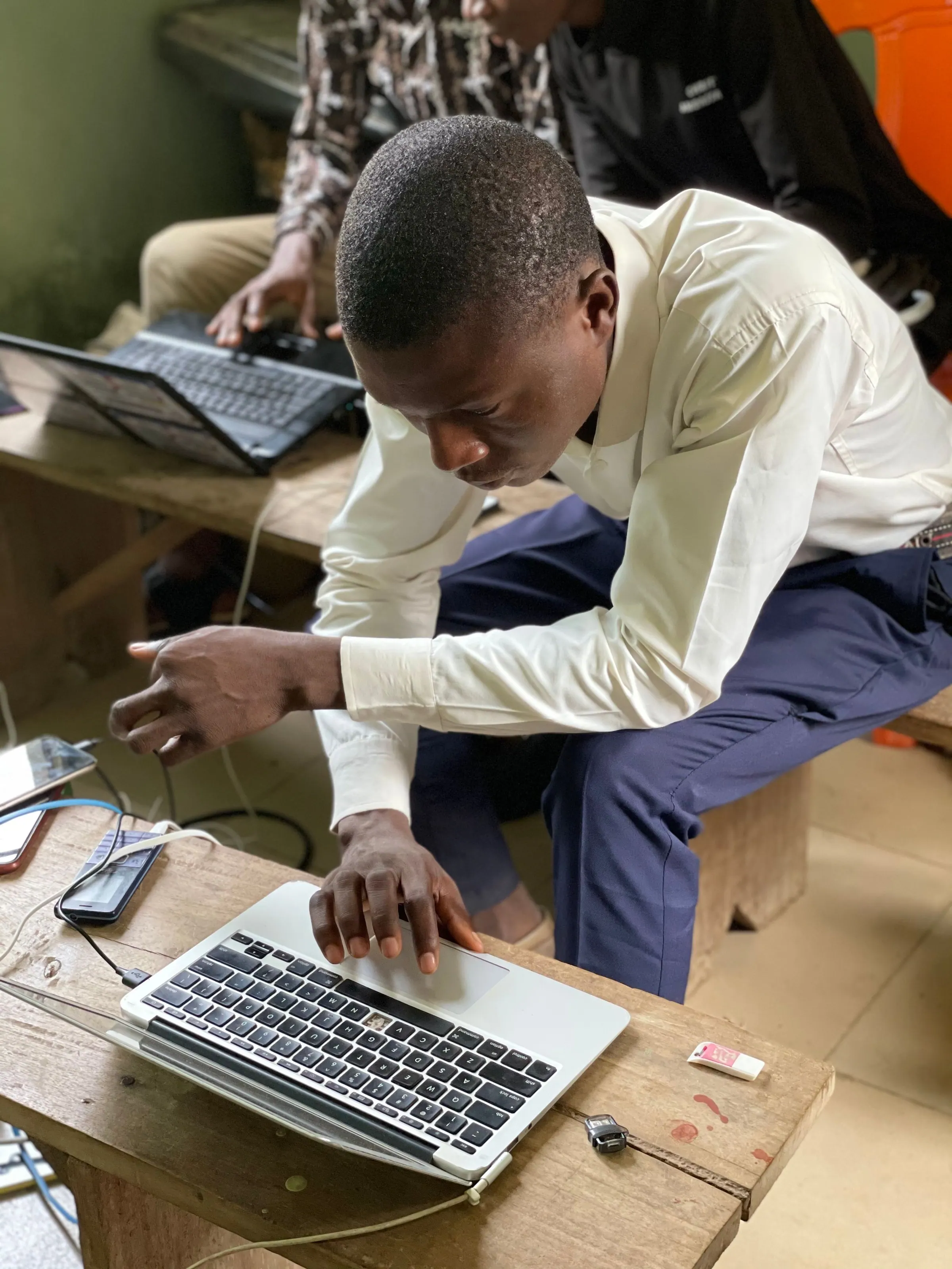 A young man learning on a laptop in a training room