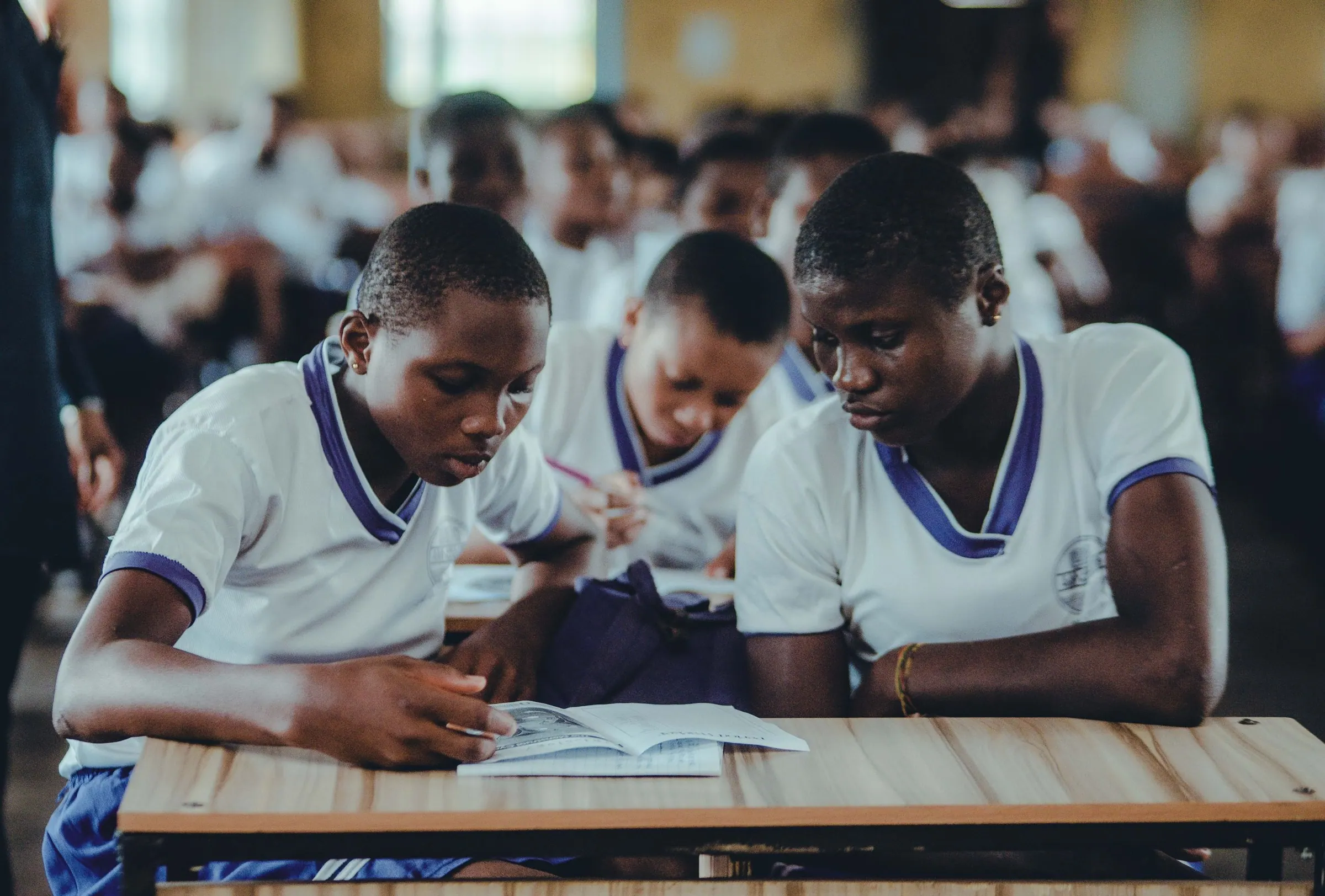 Secondary school students reading together at a desk